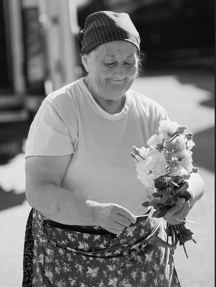 Obor Market - o femeie aranjând un buchet de flori, un portret în stil documentar.