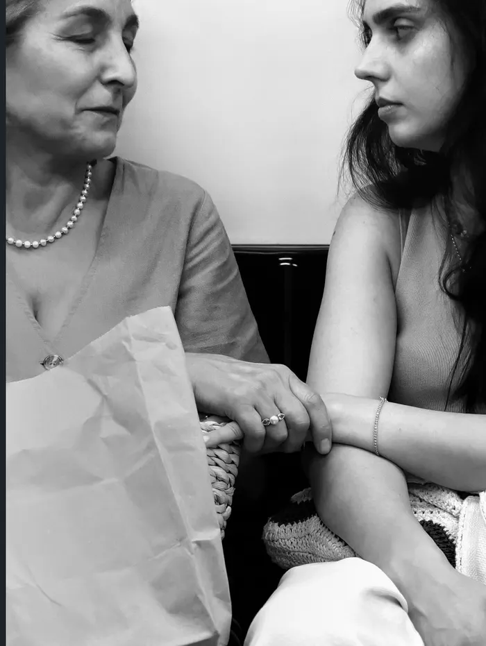 Human Connection - o mamă și o fiică ținându-se de mână, un gest discret de conexiune.